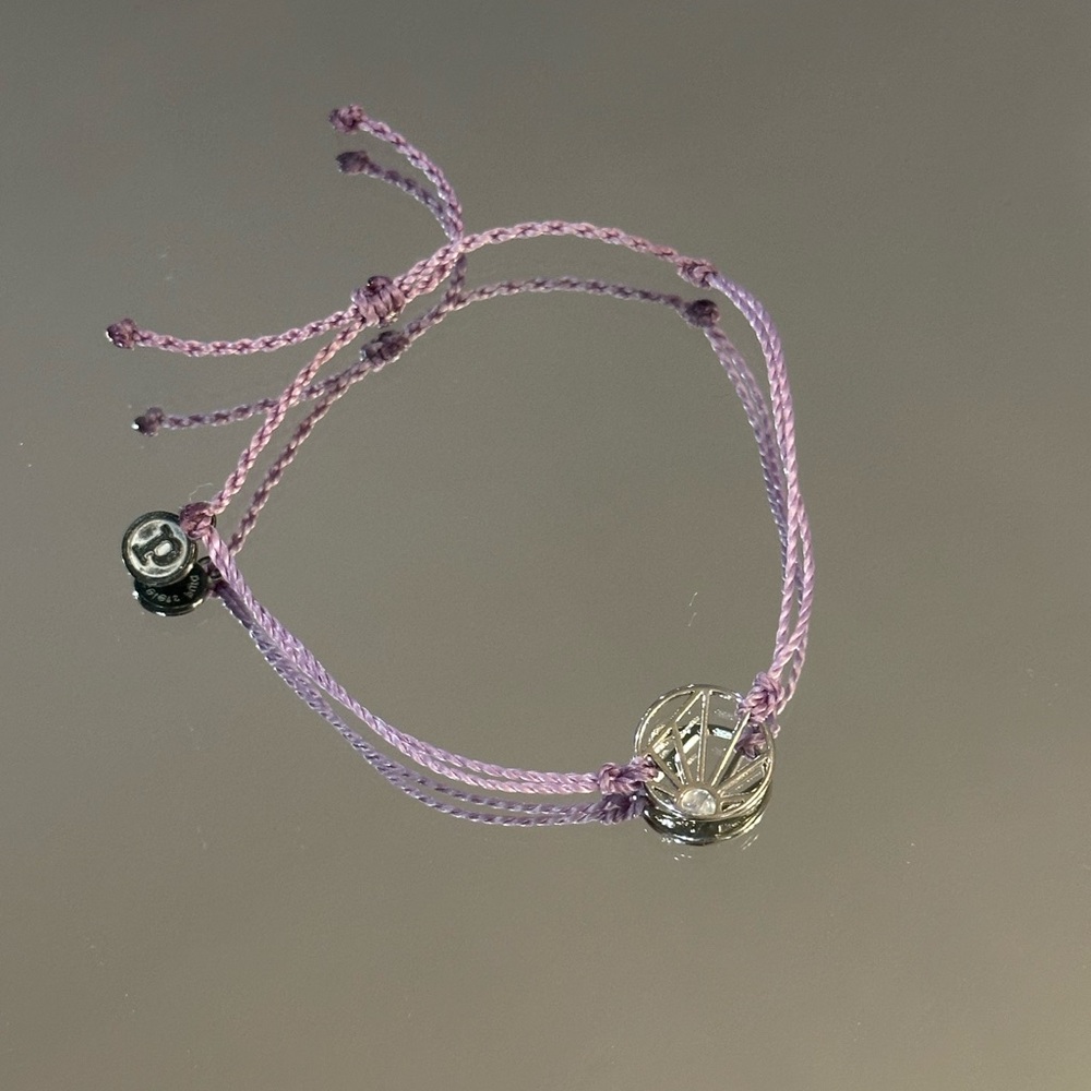 Pura Vida Lavender Adjustable Cord Bracelet with Silver Sunburst Design.